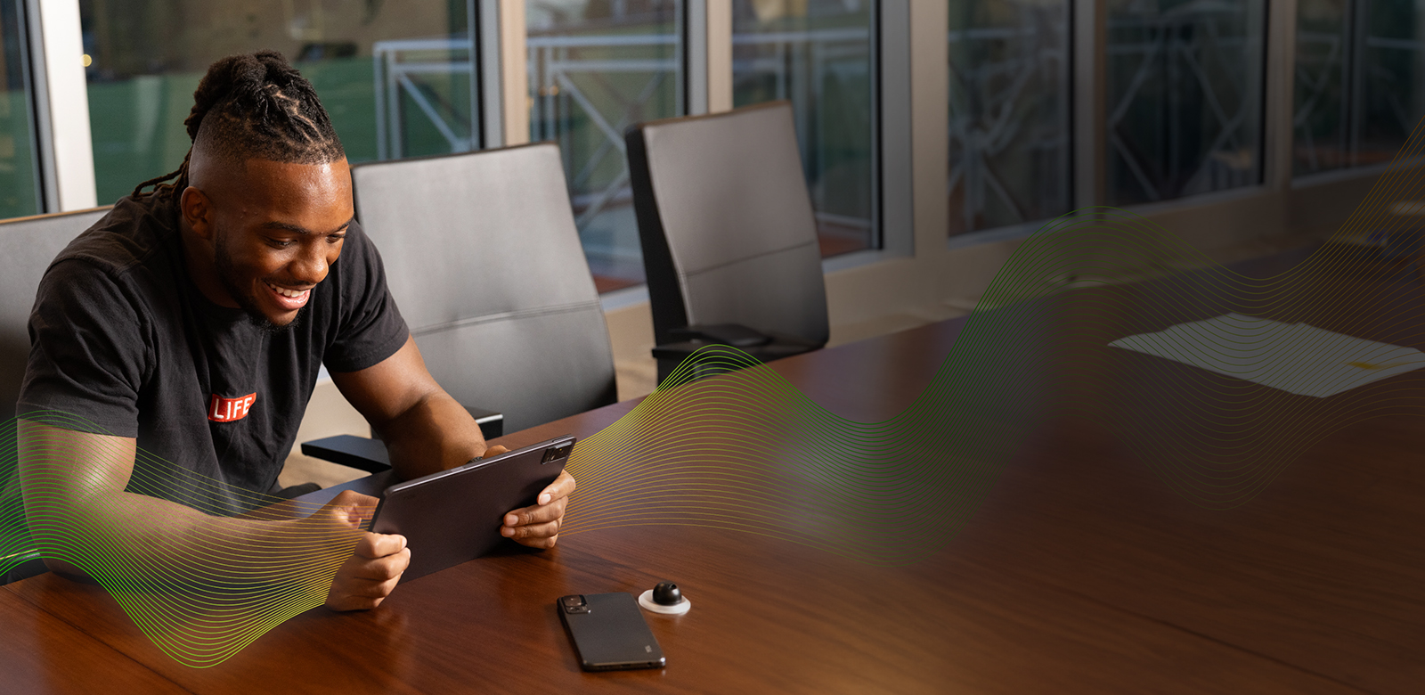 Bijan Robinson holding tablet with sound waves emitting