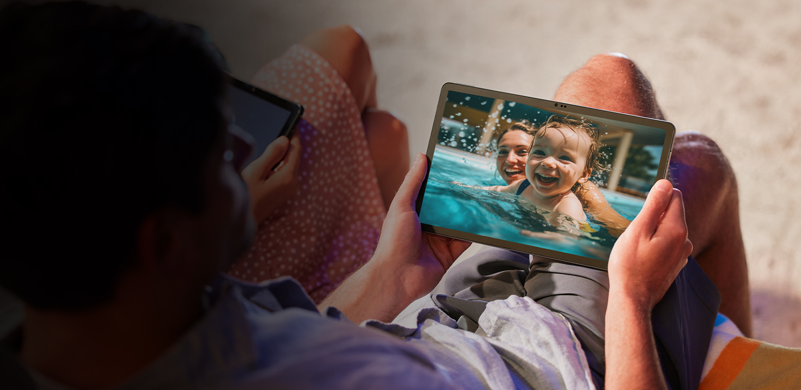 over the shoulder view of man looking at photos on tablet